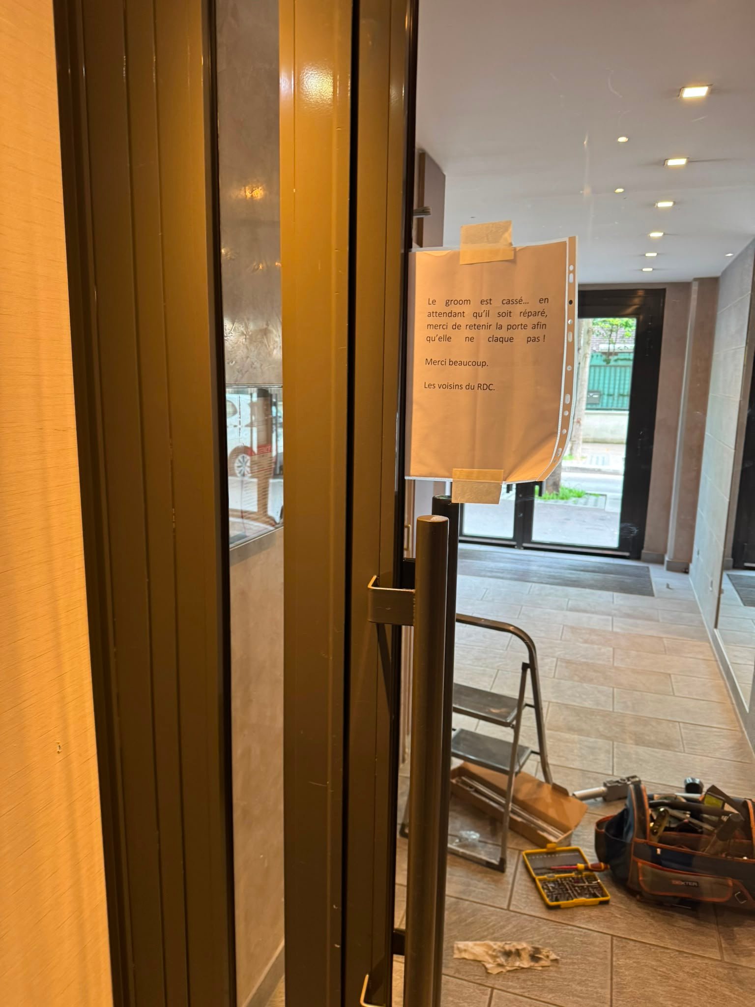 Réparation de ferme-porte sur une entrée d'immeuble